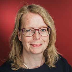 das foto zeigt das Gesicht von Anneke Schwier vor rotem Hintergrund